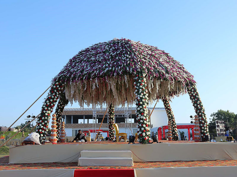 Come progettare un palco per matrimoni all'aperto in India decorato con fiori?